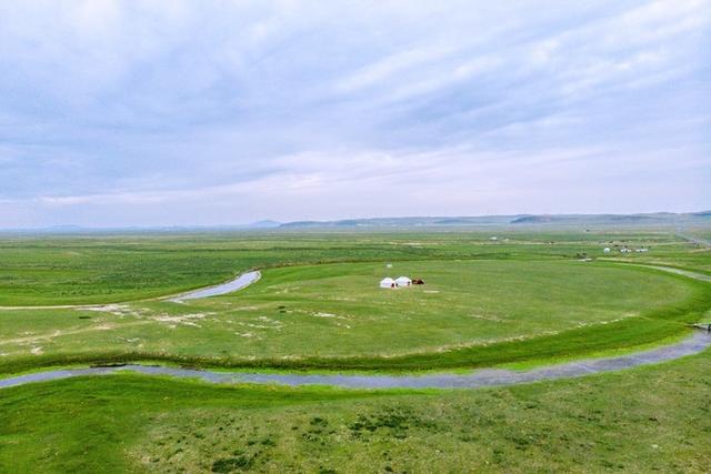 绿草如茵的平原上有着一条细细的河,袒露在